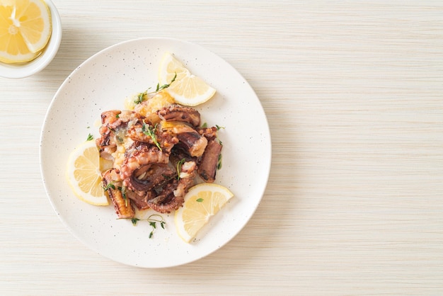 gegrillter Oktopus oder Tintenfisch mit Butter-Zitronen-Sauce und Thymian