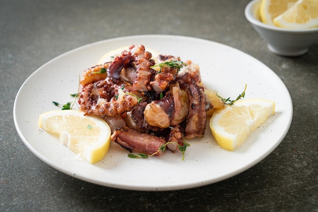 gegrillter Oktopus oder Tintenfisch mit Butter-Zitronen-Sauce und Thymian