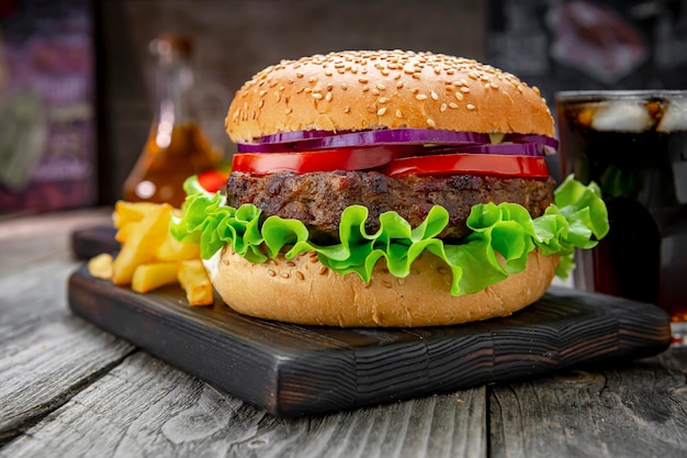 Gegrillter Rindfleischburger mit Tomatenzwiebeln und Bratkartoffeln