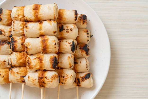 Gegrillter röhrenförmiger Fischpastenkuchen oder Röhrenkalmarspieß auf Teller