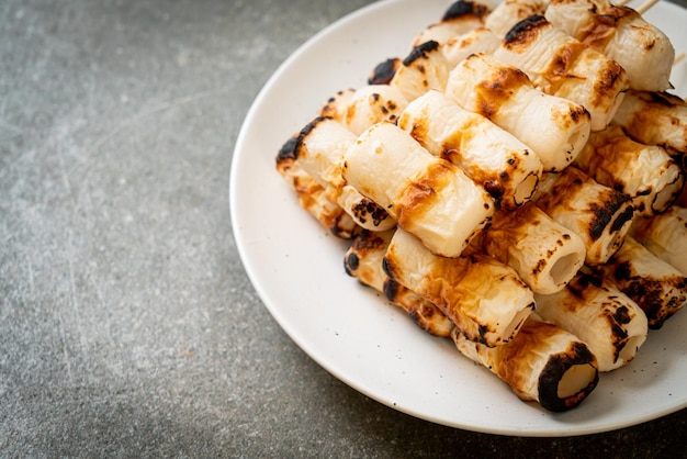 Gegrillter röhrenförmiger Fischpastetenkuchen oder Röhren-Tintenfischspieß auf Teller