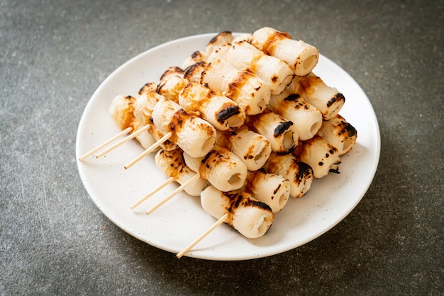 Gegrillter röhrenförmiger Fischpastetenkuchen oder Röhren-Tintenfischspieß auf Teller