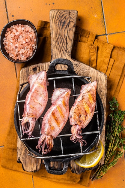 Gegrillter Tintenfisch Calamary auf einem heißen flammenden orangefarbenen Hintergrund Draufsicht