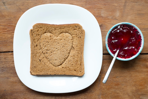 Gegrillter Toast mit Herzprägung und Teller mit Marmelade