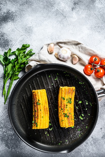 Gegrillter Zuckermais mit Paprika, Salz und Koriander. Grauer Hintergrund. Draufsicht. Platz für Text