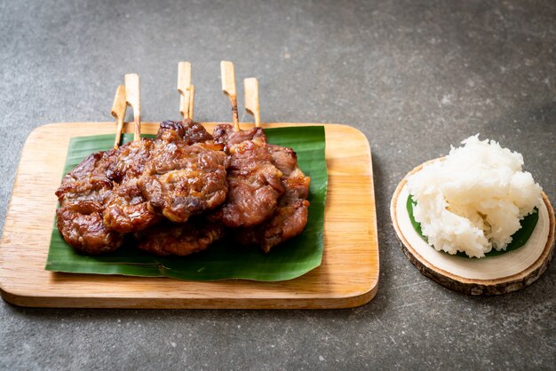 gegrilltes aufgespießtes Milchschweinefleisch mit weißem klebrigem Reis