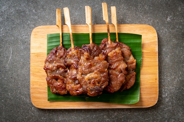 Gegrilltes aufgespießtes milchschweinefleisch mit weißem klebrigem reis