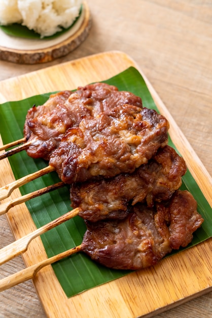 gegrilltes aufgespießtes Milchschweinefleisch mit weißem klebrigem Reis