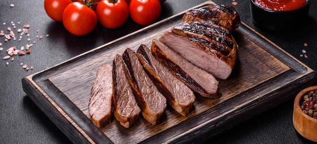 Gegrilltes Chuck Eye Roll Steak auf einem Schneidebrett gekocht. Dunkler Hintergrund