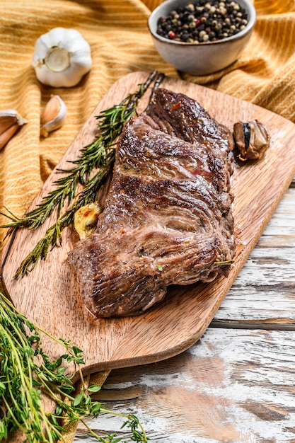 Gegrilltes Flankensteak auf einem Schneidebrett mit Gewürzen und Gewürzen. Draufsicht