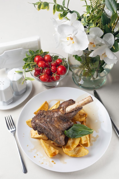 Gegrilltes Fleisch auf einem weißen Teller in einem servierten Restaurant