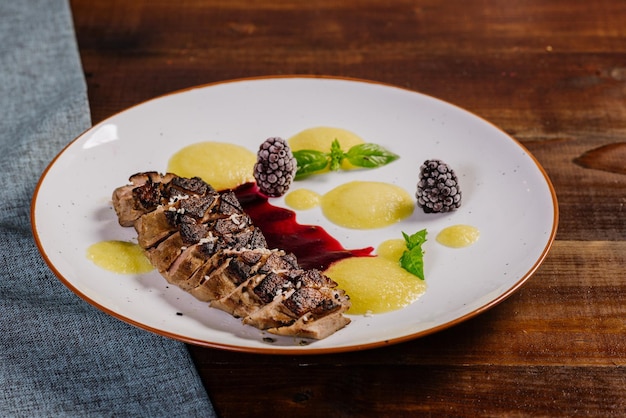 Gegrilltes Fleisch mit Fruchtsoße auf dem hölzernen Hintergrund