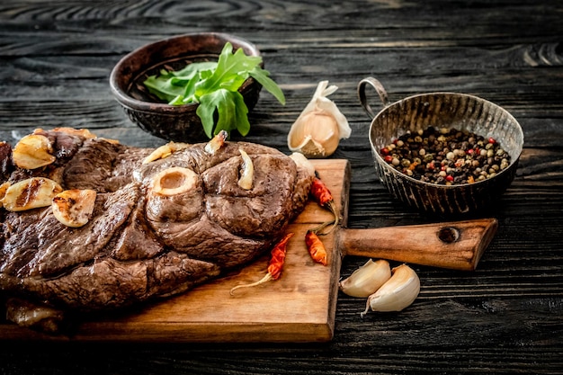 Gegrilltes Fleisch mit Knoblauch auf einem Holzbrett