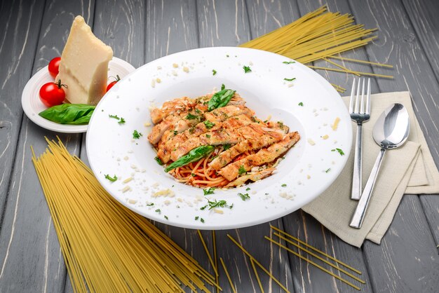 Gegrilltes Fleisch mit Nudeln, Käse, Basilikum und Tomatensauce