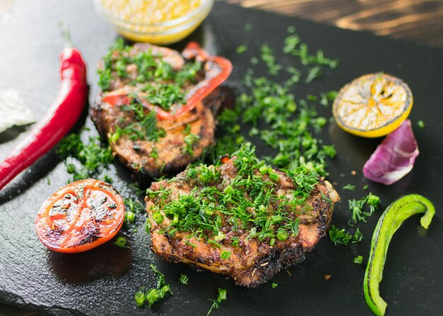 Gegrilltes Fleisch, serviert mit Gemüsegewürzen auf einer Schieferplatte