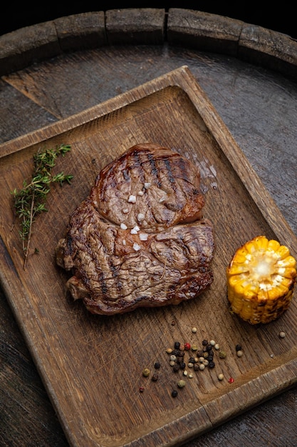 gegrilltes Fleischsteak auf einem Holzbrett mit Gewürzen in einem Premium-Restaurant