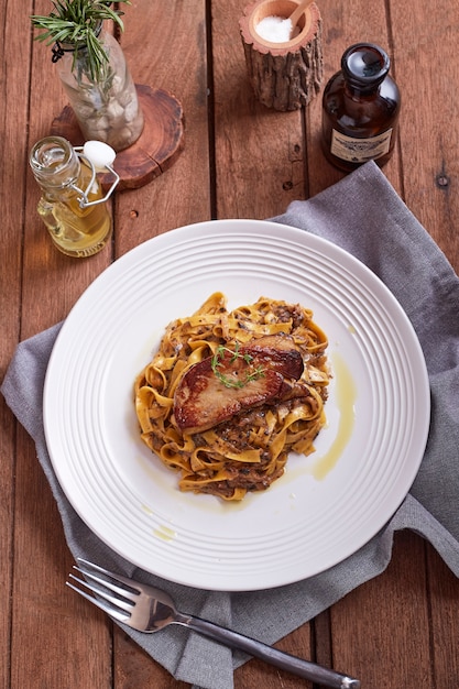 Gegrilltes Foie Gras Steak mit Fettuccine Pasta auf dem Tisch im Restaurant