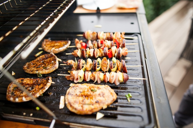 Gegrilltes frisches Fleisch und Gemüse auf dem Gasgrill, essfertig