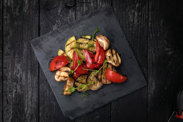 Gegrilltes Gemüse Paprika Auberginen-Champignons auf einer Schieferplatte