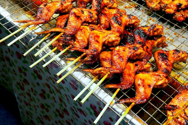 Gegrilltes Hähnchen auf dem Herd Street Food im thailändischen Stil zum Verkauf. Chicken BBQ