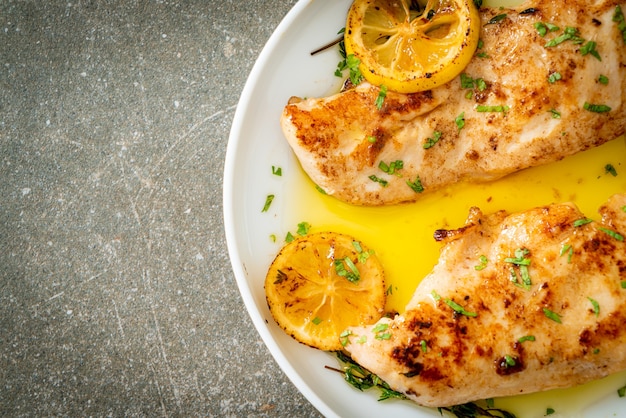 gegrilltes Hähnchen mit Butter, Zitrone und Knoblauch auf weißem Teller