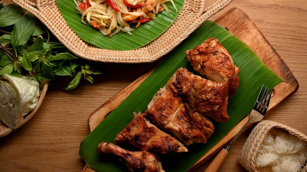 Gegrilltes hähnchen nach thailändischer art mit somtum- oder papayasalat und klebreis traditionelles thai-essen