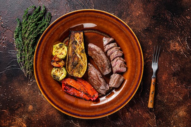 Gegrilltes Hammelfilet Filetfleisch, Lammfilet auf rustikalem Teller mit Gemüse