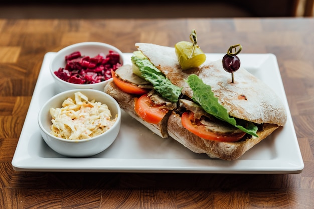 Gegrilltes Hühnersandwich mit hausgemachtem Brot, Tomaten und Salat mit Rote Beete