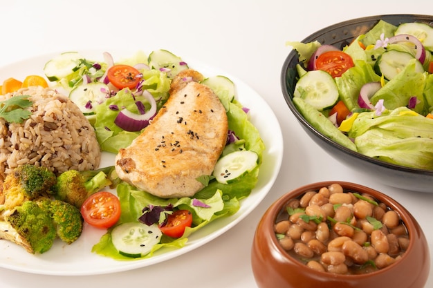 Gegrilltes Huhn in einem Teller mit Salat und Reis isoliert sauber weißer Hintergrund Top-View-Foto