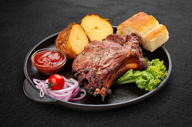 Gegrilltes Kalbssteak mit Ofenkartoffeln Matnakash und roter Sauce Serviert in einer gusseisernen Pfanne