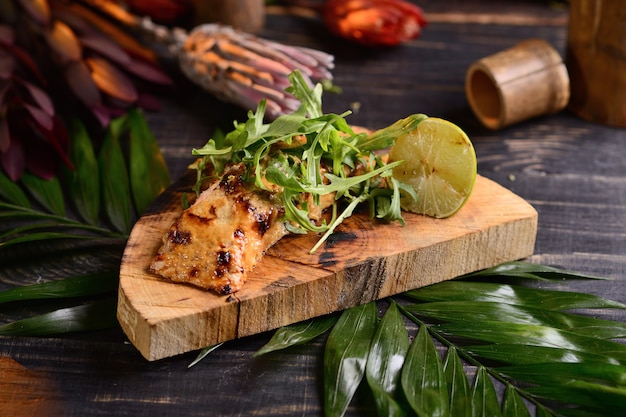 Gegrilltes Lachssteak mit Limette und Rucola. auf einem Holzbrett