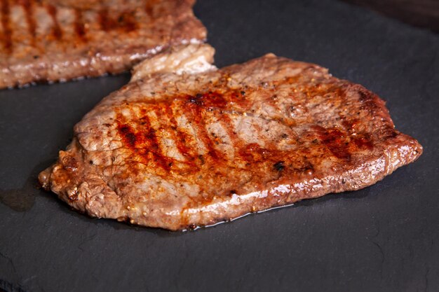 Gegrilltes Minutensteak aus marmoriertem Rindfleisch auf einer Steinplatte aus nächster Nähe