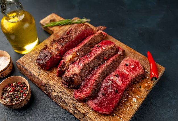 Gegrilltes Rib-Eye-Rindersteak mit Kräutern und Gewürzen auf Steinhintergrund