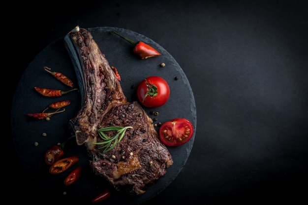 Gegrilltes Rindersteak auf Knochen mit Tomaten