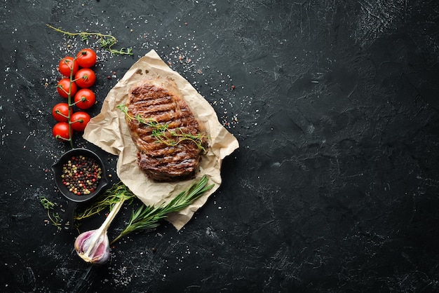 Gegrilltes Rindersteak Medium Rare auf einem schwarzen Steintisch Draufsicht Freier Platz für Ihren Text