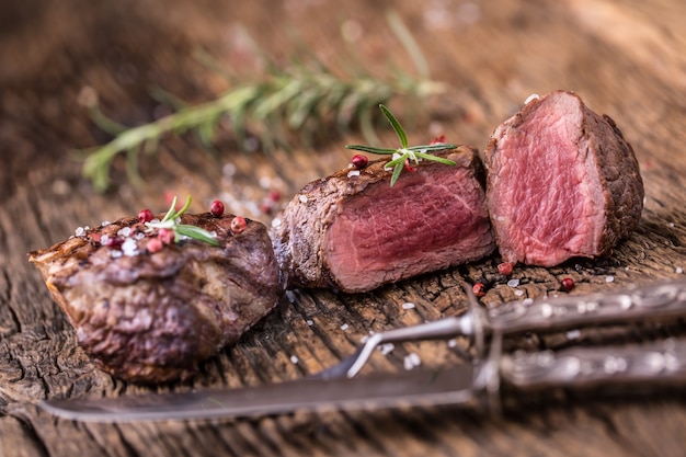 Gegrilltes Rindersteak mit Rosmarin, Salz und Pfeffer auf altem Schneidebrett. Rinderfiletsteak.