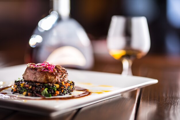 Gegrilltes Rindersteak mit schwarzen Linsen gemischt mit pflanzlichem Cognac-Rum oder Brandy als Getränk