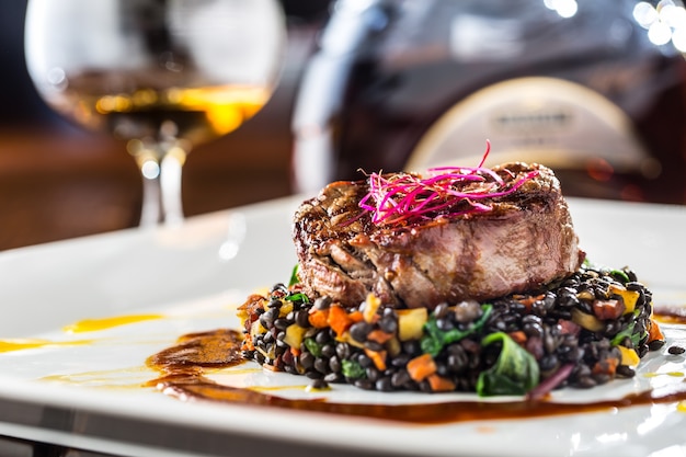 Gegrilltes Rindersteak mit schwarzen Linsen gemischt mit pflanzlichem Cognac-Rum oder Brandy als Getränk