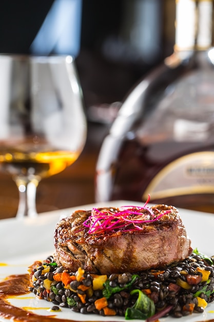 Gegrilltes Rindersteak mit schwarzen Linsen gemischt mit pflanzlichem Cognac-Rum oder Brandy als Getränk