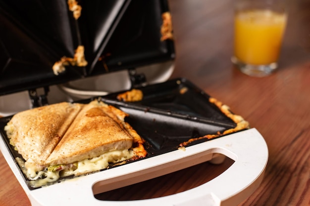Gegrilltes Sandwich mit Käse und Kräutern in einem Sandwichmaker Leichtes Snack-Frühstück