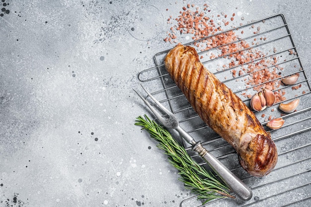 Gegrilltes Schweinefiletfiletfleisch auf dem Grill. Grauer Hintergrund. Ansicht von oben. Platz kopieren.