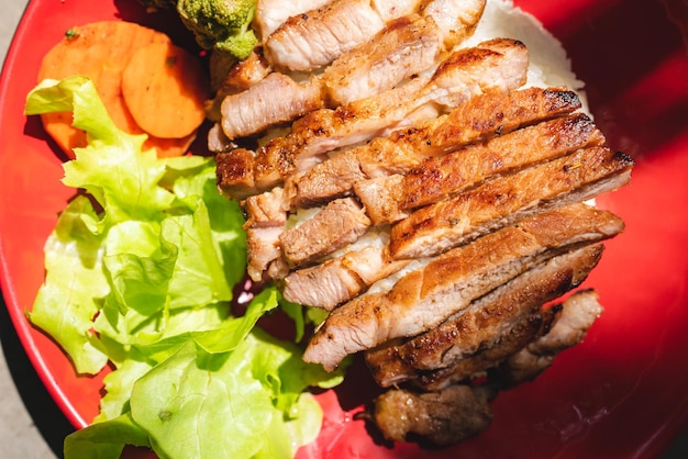 Gegrilltes Schweinefleisch nach thailändischer Art mit Reis und Gemüsemehl als Hauptgericht zum Abendessen oder Mittagessen