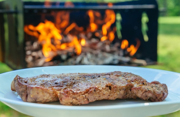 Gegrilltes Schweinefleisch und verschiedenes Gemüse auf einem Hackholz