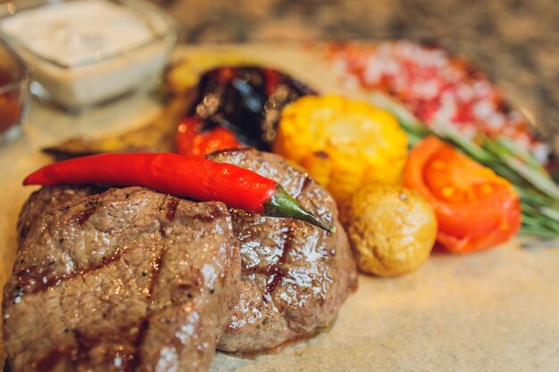 Gegrilltes Seiki auf einem Holzbrett mit Kartoffelsauce und Gemüse