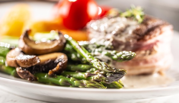 Foto gegrilltes steak auf einem teller mit spargelpilzen und sauce