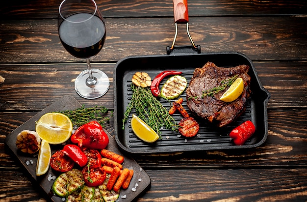 Gegrilltes Steak mit Gewürzen und einer Flasche Wein, ein Glas auf Holz! köstliches Abendessen