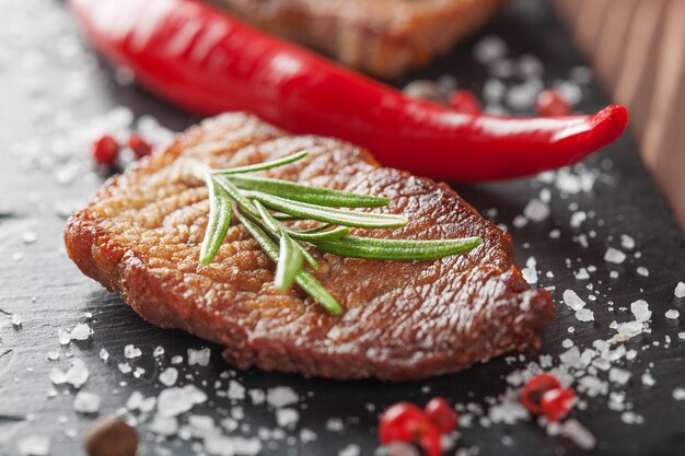 Gegrilltes Steak mit Rosmarin und Chili auf dunklem Stein