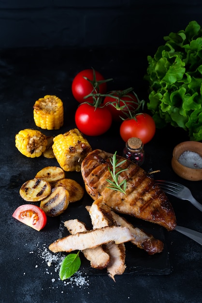 Gegrilltes Steak und Gemüse, Ofenkartoffeln und grüner Salat auf Dunkelheit