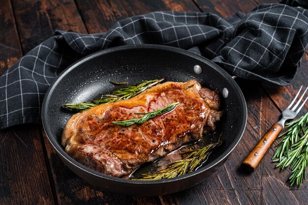 Gegrilltes Striploin-Rinderfleischsteak in einer Pfanne mit Kräutern