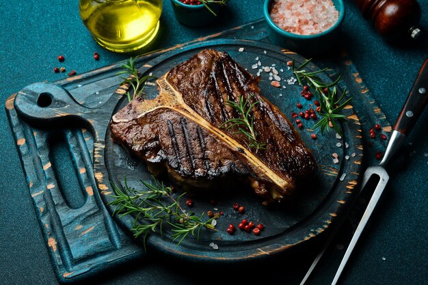 Gegrilltes T-Knochen-Steak Rindfleisch auf einem schwarzen Holzteller Fleisch